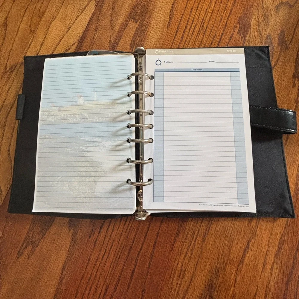 Black Leather (?) Day Timer Planner with Extra pages.